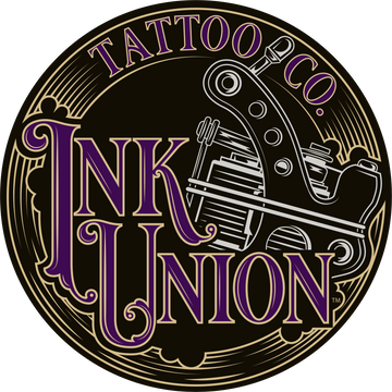 The Ink Union Tattoo Co. logo is a gold ornate circle containing the words ink union in a sizeable fancy script in gold and purple on the bottom half of the circle. Peeking out from behind the script is a silver tattoo machine. Across the top of the circle in smaller gold and purple lettering is the words Tattoo Co.