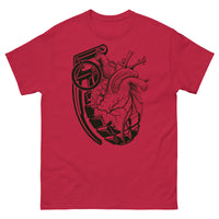 A cardinal red t-shirt with a black grenade of sold color and line work morphing into an anatomical heart drawn using line work and hatching for shading at the top right of the image.