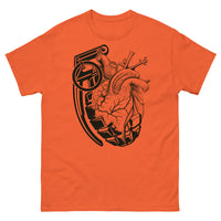 An orange t-shirt with a black grenade of sold color and line work morphing into an anatomical heart drawn using line work and hatching for shading at the top right of the image.