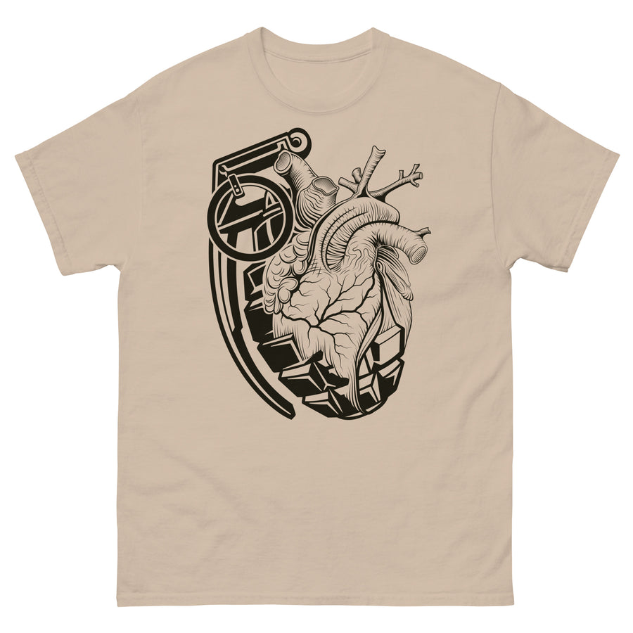 A sandy brown t-shirt with a black grenade of sold color and line work morphing into an anatomical heart drawn using line work and hatching for shading at the top right of the image.