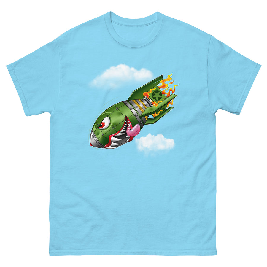 A sky blue t-shirt with a military green neo-traditional bomb tattoo design. The bomb is falling with a look of determination in its eyes, an evil toothy grin, and its tongue hanging out of its mouth. Flames are coming from the back of the bomb, and some clouds are in the background.