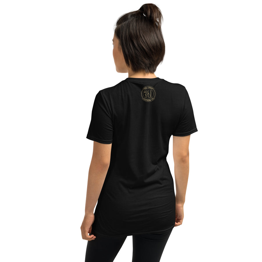 The rear view of an attractive woman wearing a black t-shirt with a small gold Ink Union Clothing Co. logo positioned just below the collar.