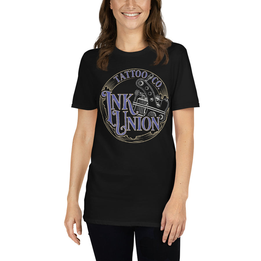 An attractive woman wearing a black t-shirt adorned with the Ink Union Tattoo Co. blue and gold with a silver tattoo machine logo.