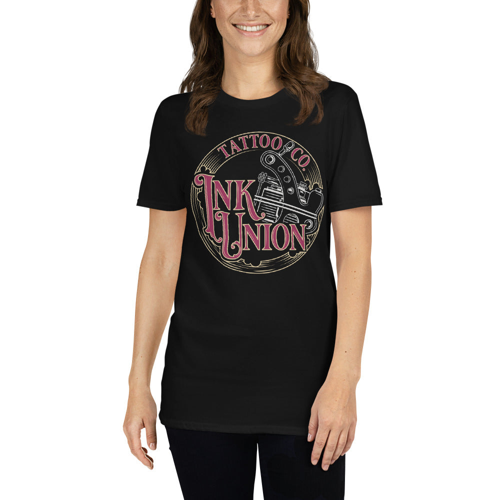 An attractive woman wearing a black t-shirt adorned with the Ink Union Tattoo Co. red and gold with a silver tattoo machine logo.