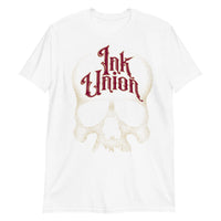 A white t-shirt adorned with a gold dot work human skull  and the words Ink Union in fancy gold and red lettering across the forehead of the skull.