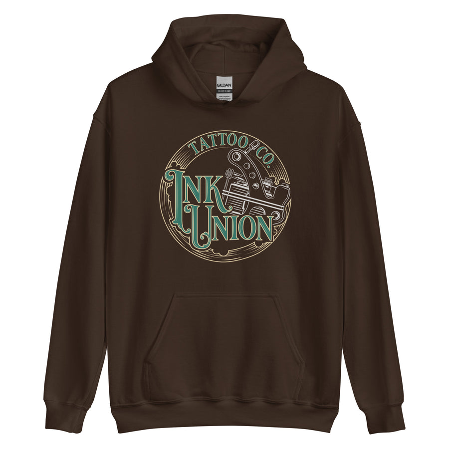 A dark brown  hoodie with a gold circle containing fancy lettering in green and gold that says Ink Union and a gold tattoo machine peeking out from behind on the right side.  There is a dot work gradient inside the circle, and the words Tattoo Co. in gold are at the bottom of the design.