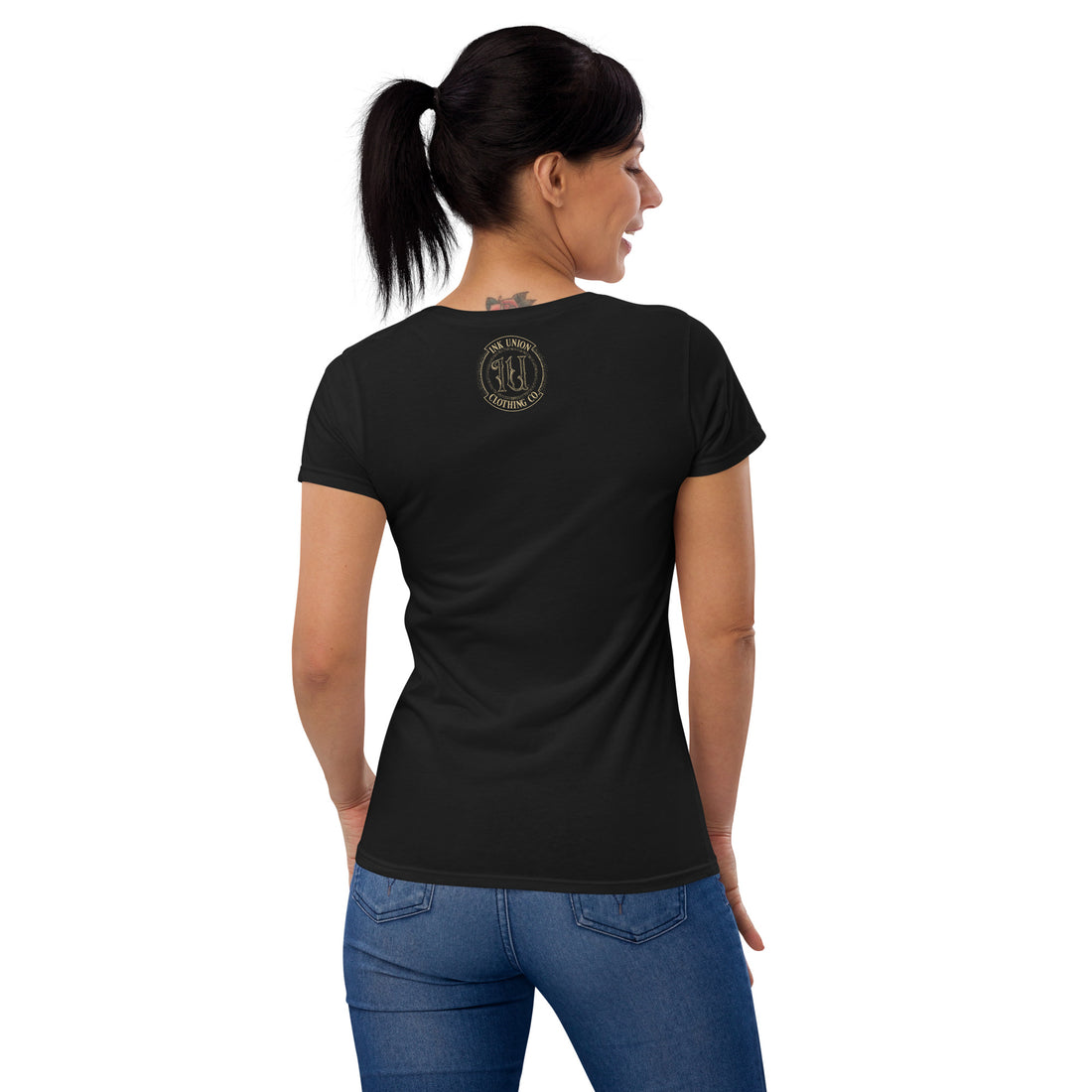 The rear view of an attractive woman wearing a black t-shirt with a small ink union logo just below the neckline.