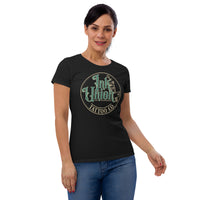 An attractive woman wearing a black t-shirt with a gold circle containing fancy lettering in green and gold that says Ink Union and a gold tattoo machine peeking out from behind on the right side.  There is a dot work gradient inside the circle, and the words Tattoo Co. in gold are at the bottom of the design.