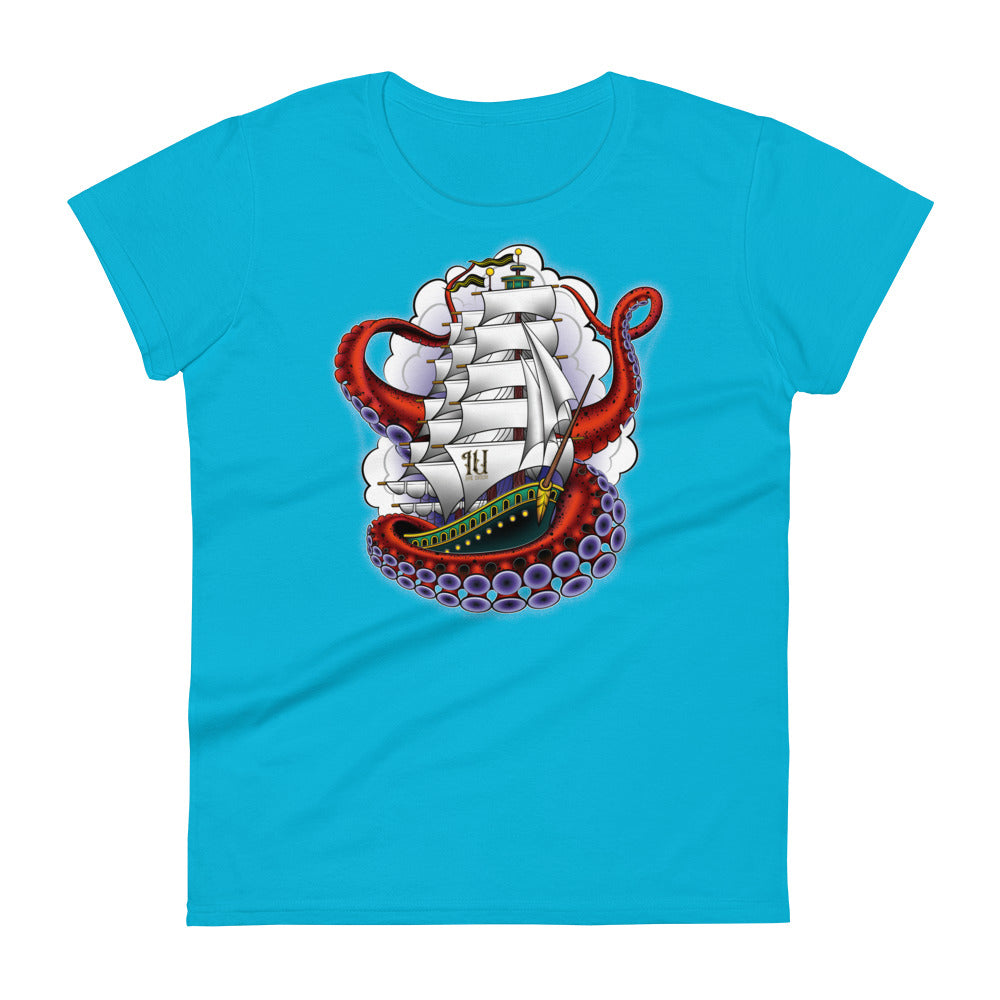 A light blue t-shirt with an old-school clipper ship tattoo design in green and brown with white sails surrounded by octopus tentacles in shades of red with purple tentacles. Behind the ship are purple-tinged clouds.