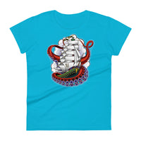 A light blue t-shirt with an old-school clipper ship tattoo design in green and brown with white sails surrounded by octopus tentacles in shades of red with purple tentacles. Behind the ship are purple-tinged clouds.