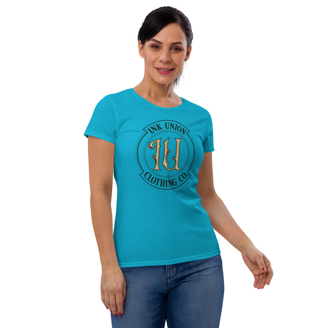 An attractive woman is wearing a light blue t-shirt with the Ink Union Clothing Co Badge logo in black and gold.