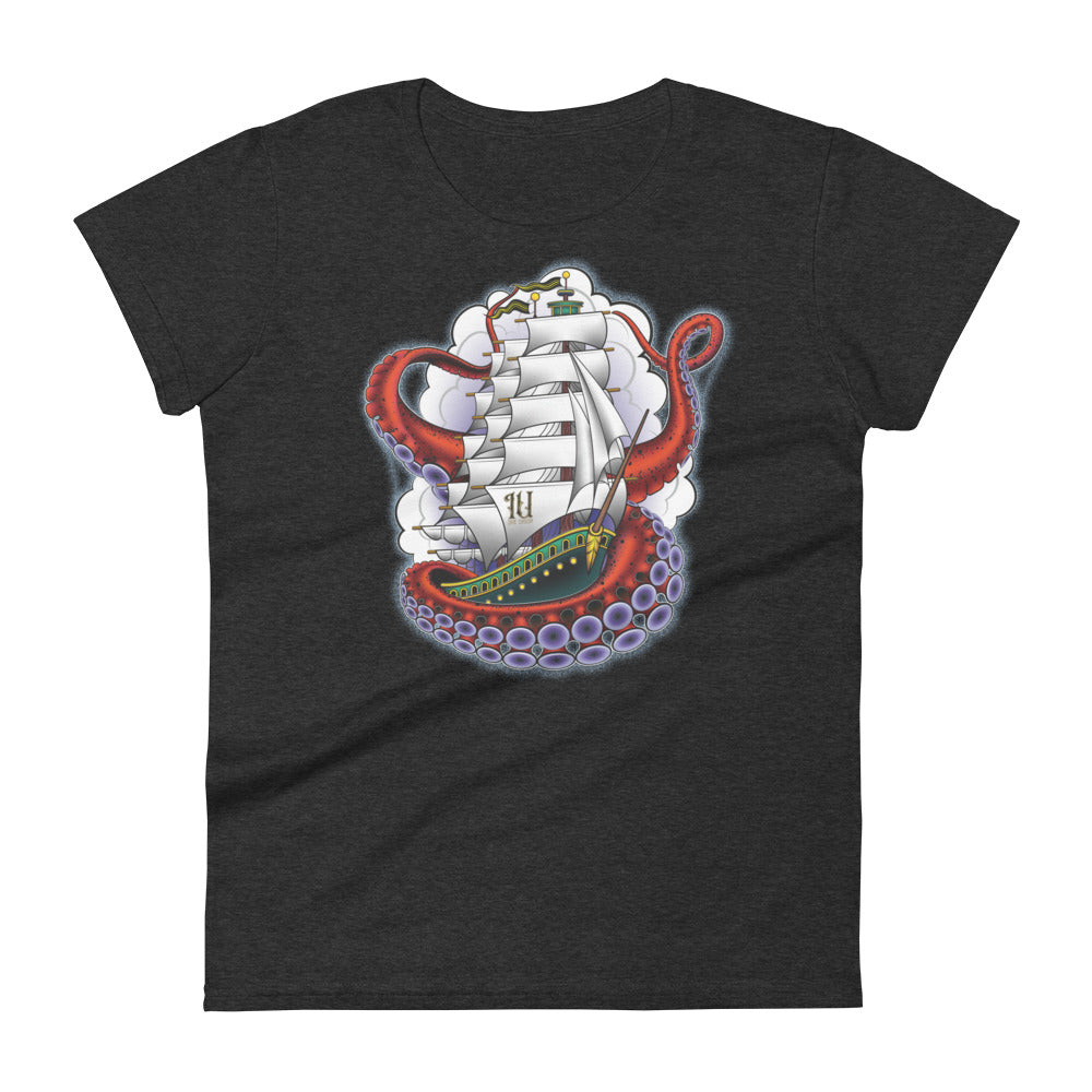A dark grey t-shirt with an old-school clipper ship tattoo design in green and brown with white sails surrounded by octopus tentacles in shades of red with purple tentacles. Behind the ship are purple-tinged clouds.