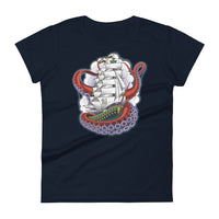 A navy t-shirt with an old-school clipper ship tattoo design in green and brown with white sails surrounded by octopus tentacles in shades of red with purple tentacles. Behind the ship are purple-tinged clouds.
