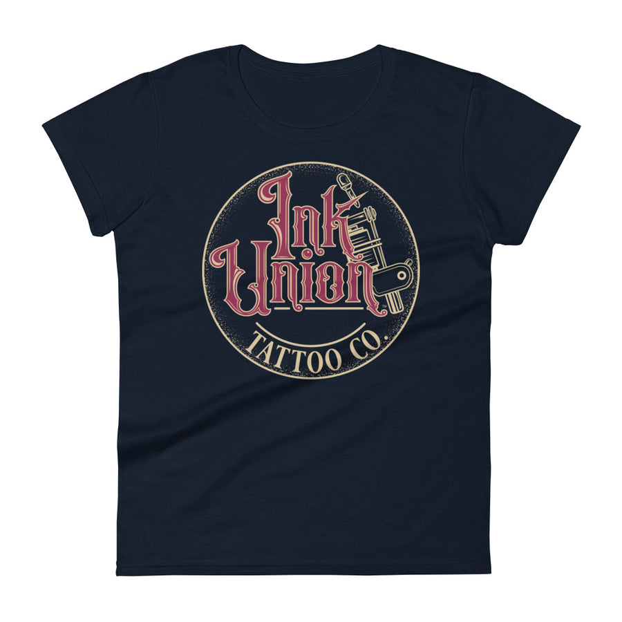 A navy blue t-shirt with a gold circle containing fancy lettering in red and gold that says Ink Union and a gold tattoo machine peeking out from behind on the right side.  There is a dot work gradient inside the circle, and the words Tattoo Co. in gold are at the bottom of the design.