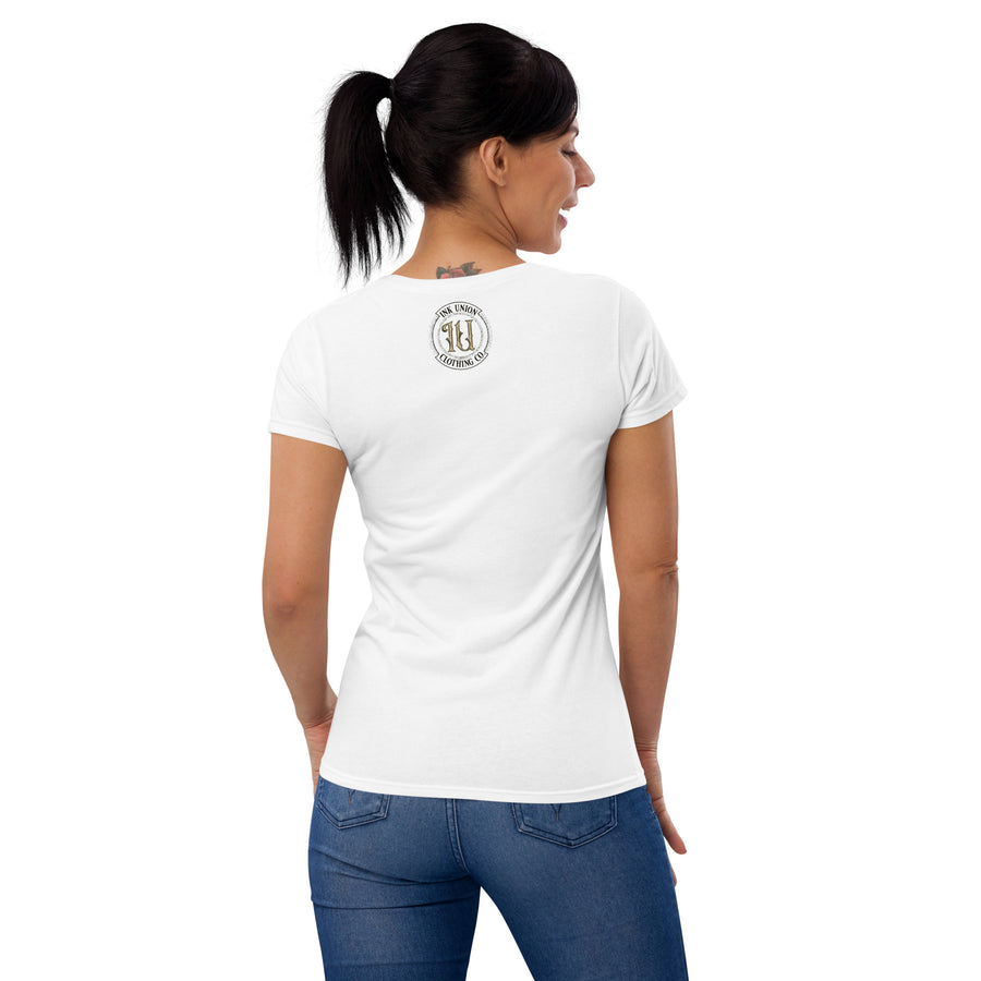The back view of an attractive woman wearing a white t-shirt with a small gold and black Ink Union badge Logo centered just under the neckline.