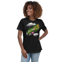 An attractive woman wearing a black t-shirt with a military green neo-traditional bomb tattoo design. The bomb is falling with a look of determination in its eyes, an evil toothy grin, and its tongue hanging out of its mouth. Flames are coming from the back of the bomb, and some clouds are in the background.