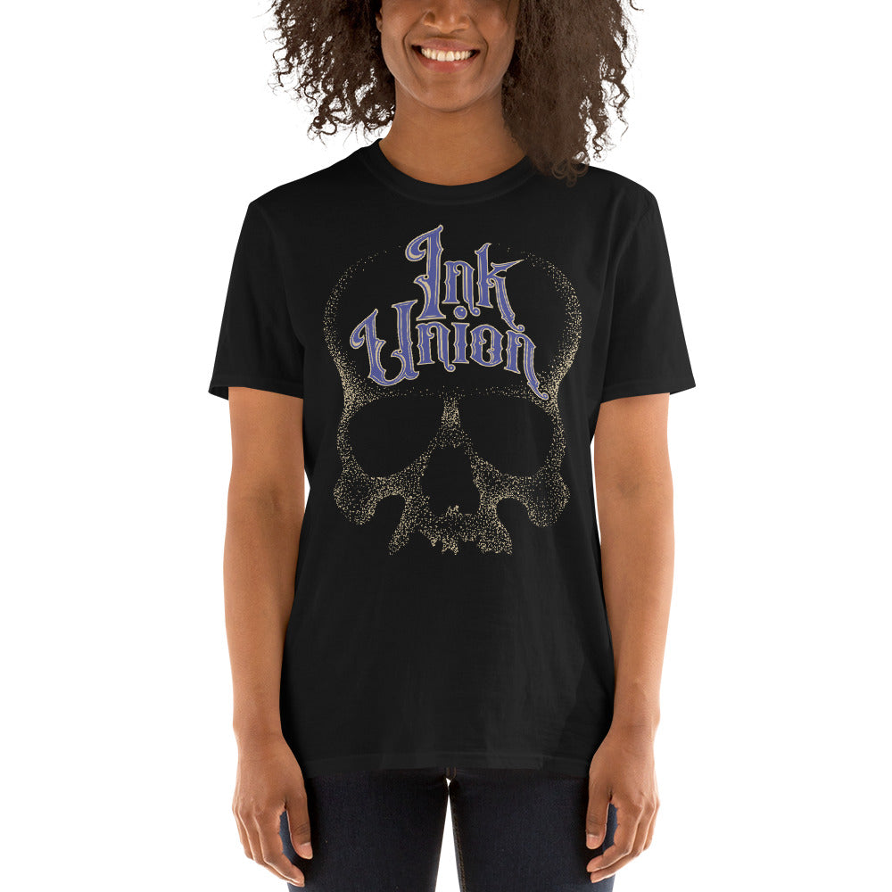 woman wearing an Ink Union Clothing Co. unisex black t-shirt  featuring a large dot work gold skull centered on the shirt and Ink Union in large fancy gold and blue script across the forehead of the skull