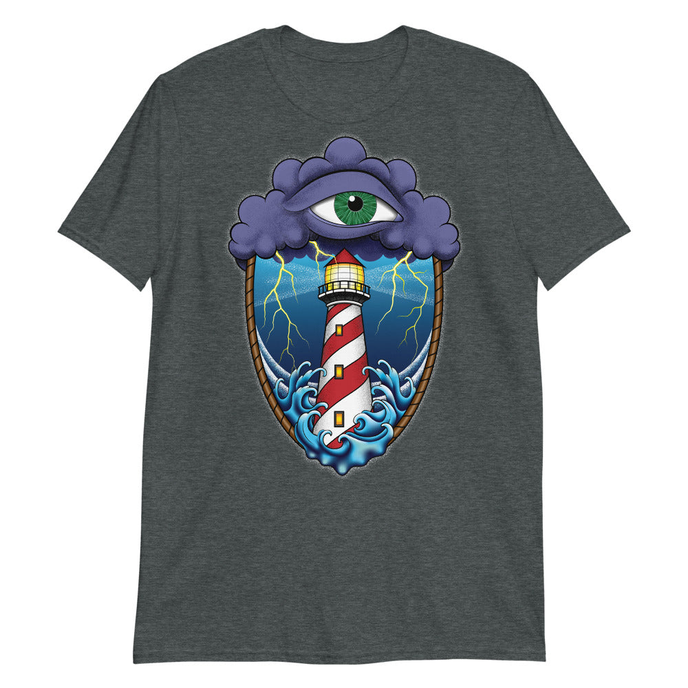 A dark grey t-shirt with an old school eye of the storm tattoo design of large dark purple storm clouds at the top of the design with a green eye in the middle of the clouds.  Below the clouds is an oval shape with brown rope. Inside the rope are stormy seas and a lighthouse with lightning striking in the background.  At the bottom of the design, some of the waves are spilling out of the rope barrier. The sky and seas are hues of blue; the lighthouse is white and red striped like a barber pole.
