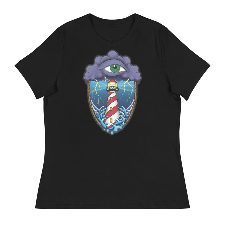 A black t-shirt with an old school eye of the storm tattoo design of large dark purple storm clouds at the top of the design with a green eye in the middle of the clouds.  Below the clouds is an oval shape with brown rope. Inside the rope are stormy seas and lightning striking at a lighthouse that is white and red striped like a barber pole.