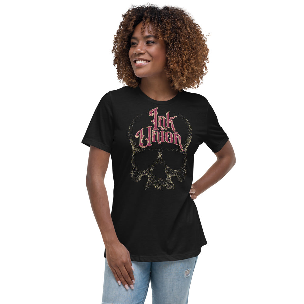 woman wearing an Ink Union Clothing Co. women's relaxed fit black t-shirt  featuring a large dot work gold skull centered on the shirt and Ink Union in large fancy gold and red script across the forehead of the skull