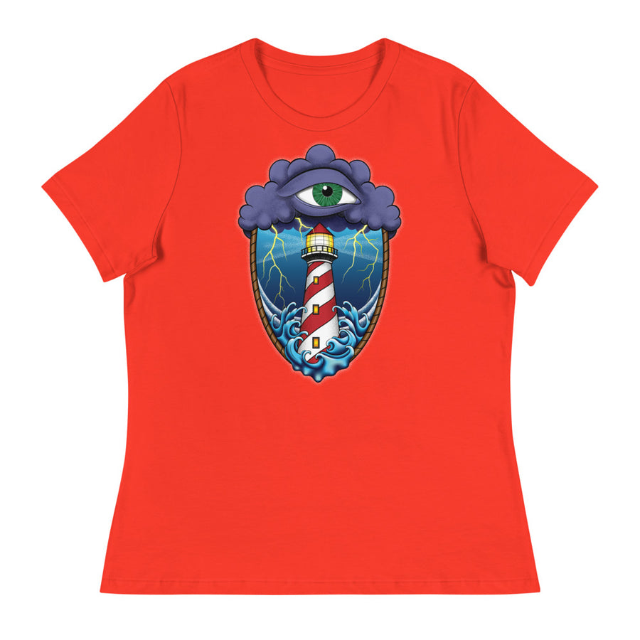 A poppy red t-shirt with an old school eye of the storm tattoo design of large dark purple storm clouds at the top of the design with a green eye in the middle of the clouds.  Below the clouds is an oval shape with brown rope. Inside the rope are stormy seas and lightning striking at a lighthouse that is white and red striped like a barber pole.